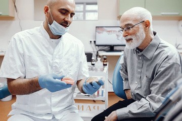 Patient and dentist in Naples talking about implant dentures