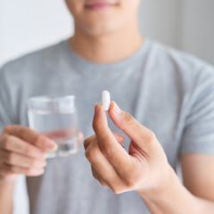 Man taking a pill with water 