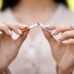 Closeup of woman breaking cigarette