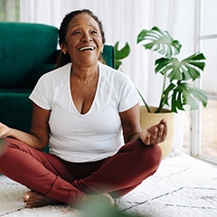 Woman smiling while meditating at home