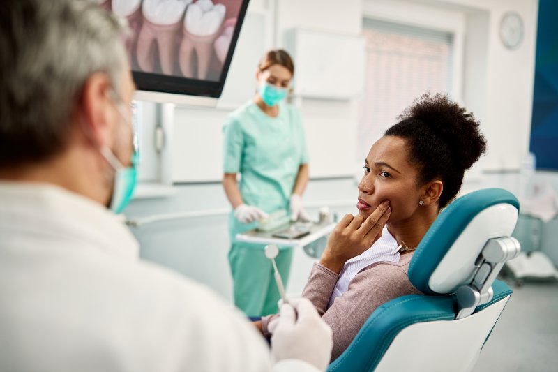 A woman seeing her dentist for her sensitive dental implant